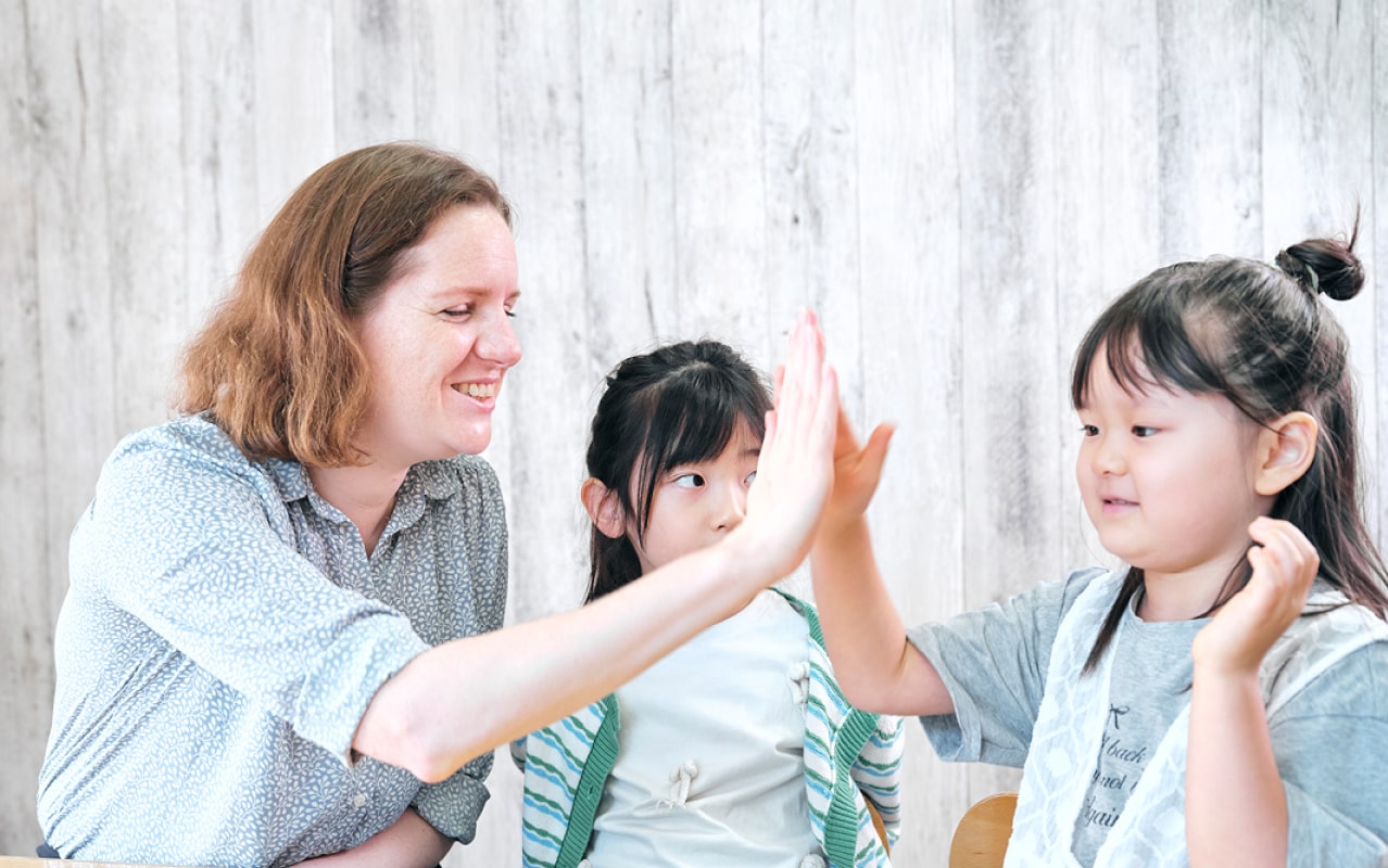 外国人講師とハイタッチする女の子