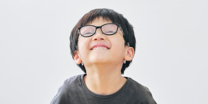 笑顔で見上げるメガネの男の子