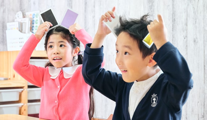 カードを使ったレッスンを楽しむ小学生