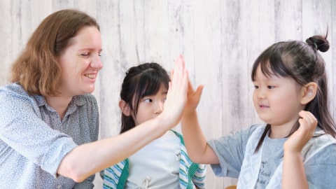 外国人講師とハイタッチをする女の子