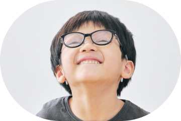 笑顔で見上げるメガネの男の子