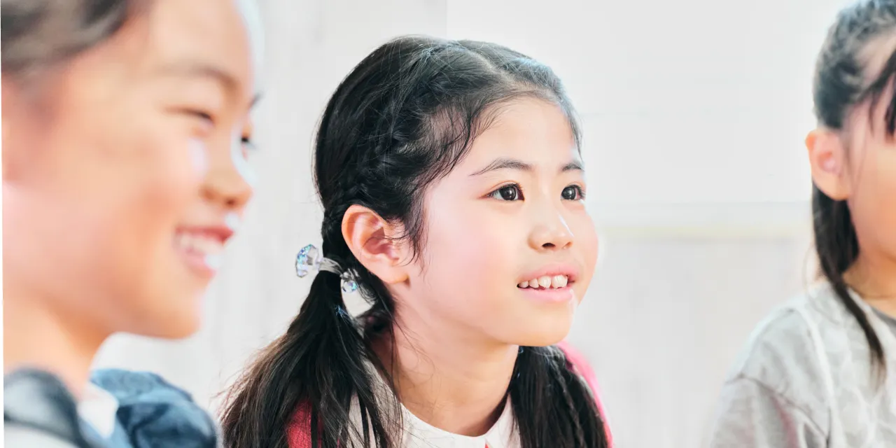 話を聞く小学生の女の子